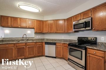 Friendswood house for rent - a kitchen with wooden cabinets and stainless steel appliances