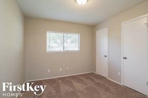 Friendswood house for rent - a bedroom with carpet and a window and a door