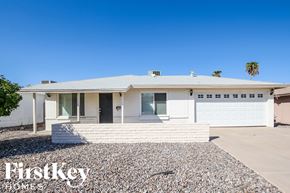 Phoenix house for rent - a white house with a driveway and a white garage door