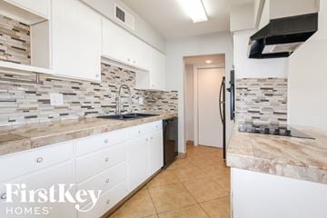 Phoenix house for rent - a white kitchen with marble counter tops and white cabinets