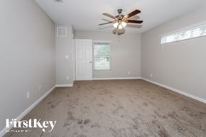 Port St. Lucie house for rent - A room with a ceiling fan and a door leading to another room.