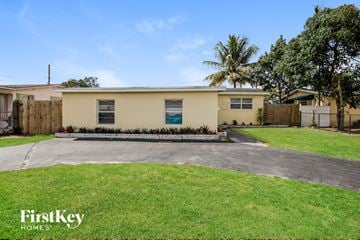 Hollywood house for rent - a home with a driveway and a lawn and a palm tree