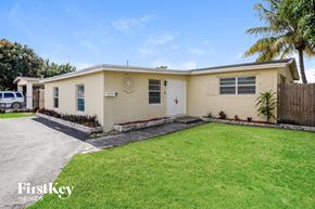 Hollywood house for rent - a beige house with a lawn and palm tree