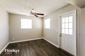 Hollywood house for rent - an empty room with a ceiling fan and a white door