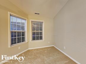 Charlotte house for rent - the second bedroom has a large window and beige carpeting