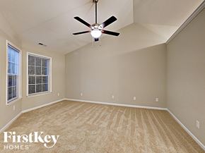 Charlotte house for rent - an empty living room with a ceiling fan and a window