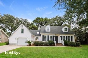 Charleston house for rent - a white house with a green lawn and trees