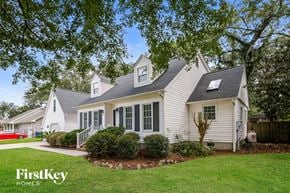 Charleston house for rent - a white house with white siding and green grass and trees