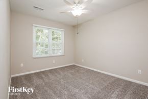 Charleston house for rent - an empty bedroom with a ceiling fan and a window