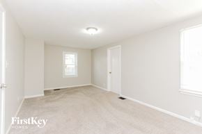 Indianapolis house for rent - A spacious room with a carpeted floor and a window.