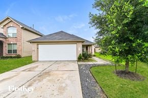 Houston house for rent - a home with a white garage door and a tree
