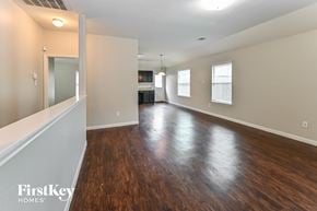 Houston house for rent - an empty living room with wood flooring and a kitchen