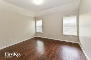 Houston house for rent - a living room with wood flooring and white walls and two windows