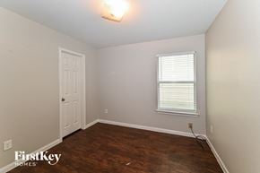 Houston house for rent - a bedroom with a wooden floor and a white door