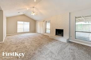 Spring house for rent - A spacious living room with a fireplace and a ceiling fan.