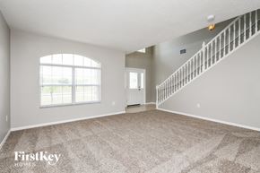 Kissimmee house for rent - an empty living room with a staircase and a window