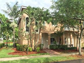 Homestead house for rent - a house with palm trees in front of it