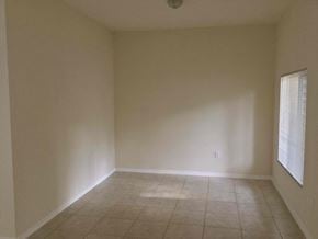 Homestead house for rent - an empty living room with a tiled floor and a window