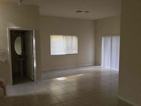 Homestead house for rent - an empty living room with a window and a tiled floor
