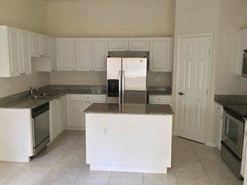 Homestead house for rent - a kitchen with white cabinets and a counter top