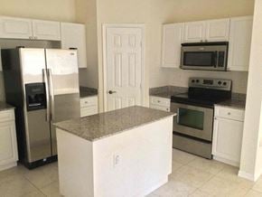 Homestead house for rent - a kitchen with stainless steel appliances and white cabinets
