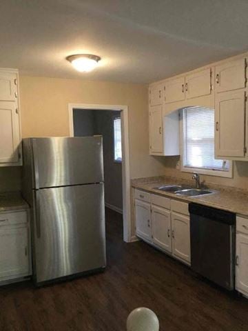 Decatur house for rent - a kitchen with white cabinets and a stainless steel refrigerator