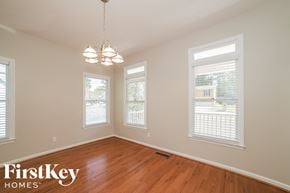 Marietta house for rent - an empty dining room with a wood floor and three windows