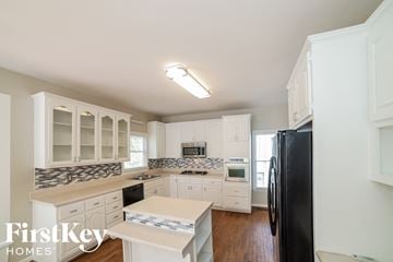 Marietta house for rent - a kitchen with white cabinets and a black refrigerator