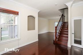 Homestead house for rent - a view of the entryway of a home with a staircase and a large window