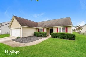 Greensboro house for rent - a small yellow house with red doors and a lawn