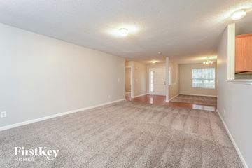 Greensboro house for rent - a spacious living room with carpet and a kitchen