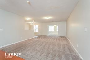 Greensboro house for rent - a spacious living room with carpet and white walls