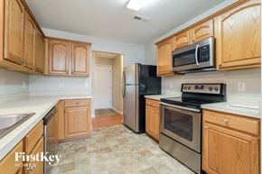 Greensboro house for rent - a kitchen with wooden cabinets and stainless steel appliances