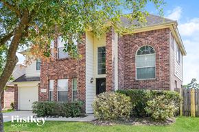 Spring house for rent - A brick house with a black door and a window.