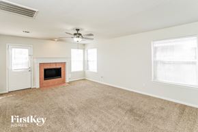 Spring house for rent - A room with a fireplace and a fan on the ceiling.