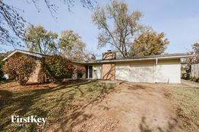 Florissant house for rent - A house with a driveway and trees in the background.
