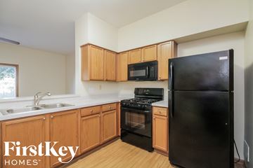Plainfield house for rent - a kitchen with black appliances and wooden cabinets