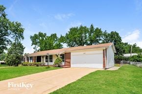 Florissant house for rent - a small brick house with a white garage door