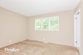 Florissant house for rent - a bedroom with beige carpet and a window