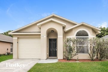Sanford house for rent - a beige house with a garage door and a lawn