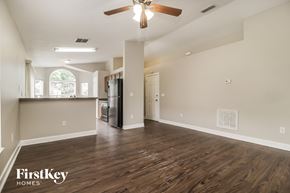 Sanford house for rent - an empty living room with a kitchen and a ceiling fan