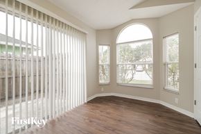 Sanford house for rent - an empty living room with wood floors and a large window