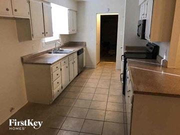 Sugar Land house for rent - a kitchen with tiled floors and white cabinets