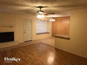 Sugar Land house for rent - an empty living room with a fireplace and a ceiling fan