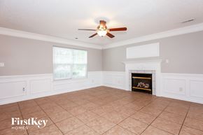 Charlotte house for rent - A spacious living room with a fireplace and a ceiling fan.