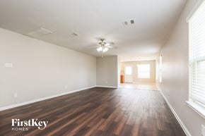Houston house for rent - A spacious room with wooden floors and a ceiling fan.