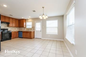 Houston house for rent - A kitchen with wooden cabinets and a black oven.