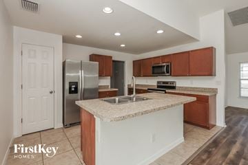 Cape Coral house for rent - A kitchen with a granite countertop and stainless steel appliances.