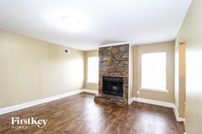 Memphis house for rent - a living room with a stone fireplace and wooden floors