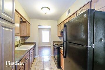 Memphis house for rent - a kitchen with black appliances and wooden cabinets